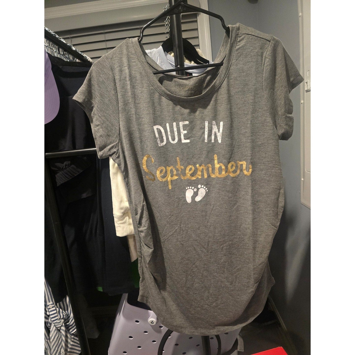 Pregnant woman wearing a comfortable maternity shirt with "Due in September" graphic design